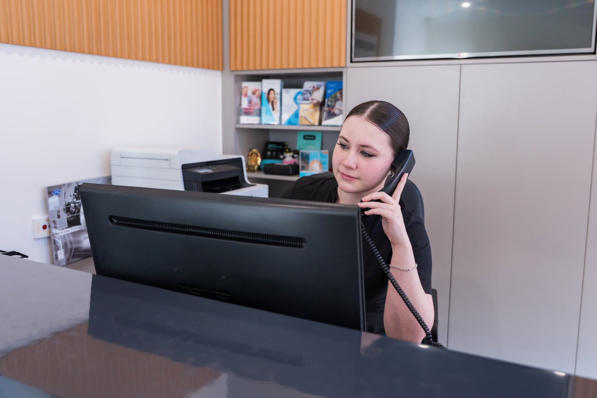 Exquisite Smiles Warner receptionist answering phone at front desk