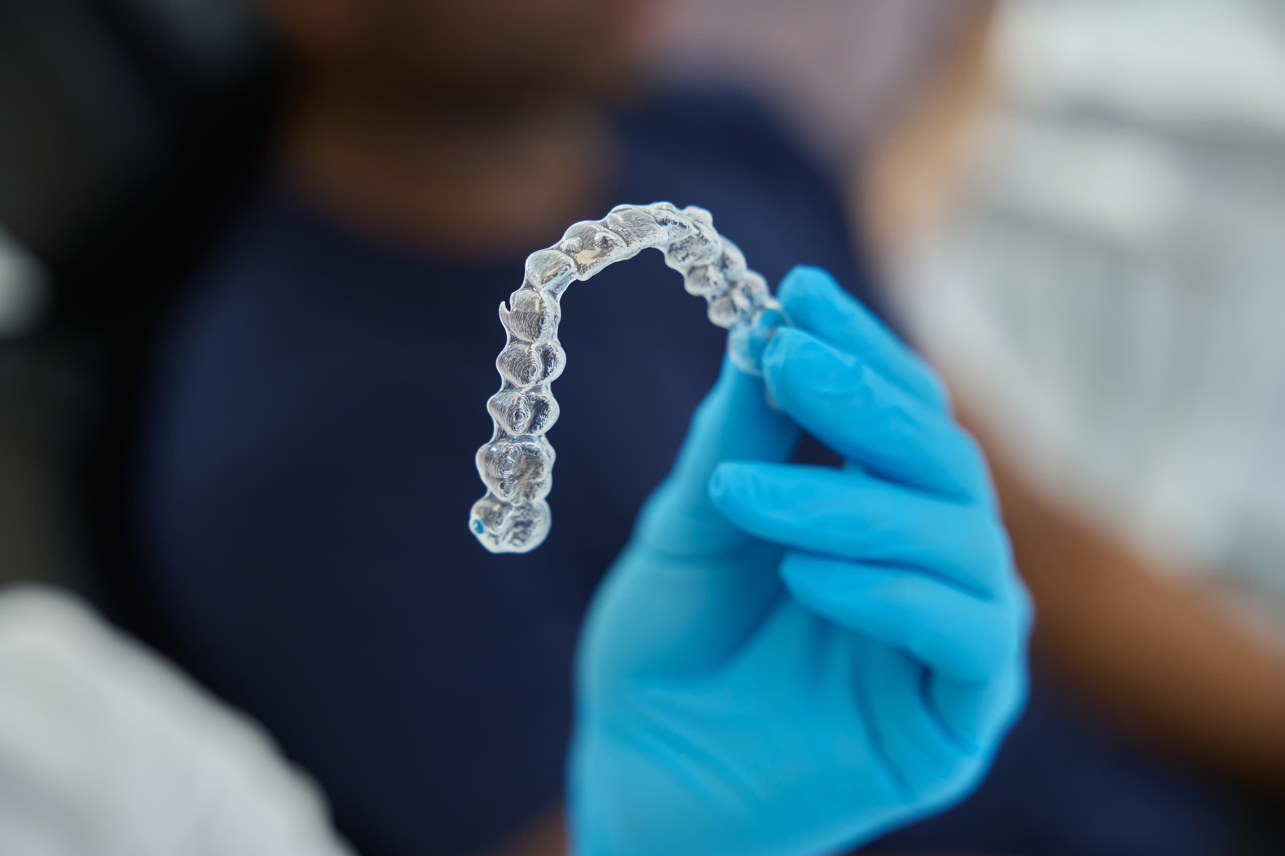 Dentist holding clear aligner used for orthodontic teeth straightening