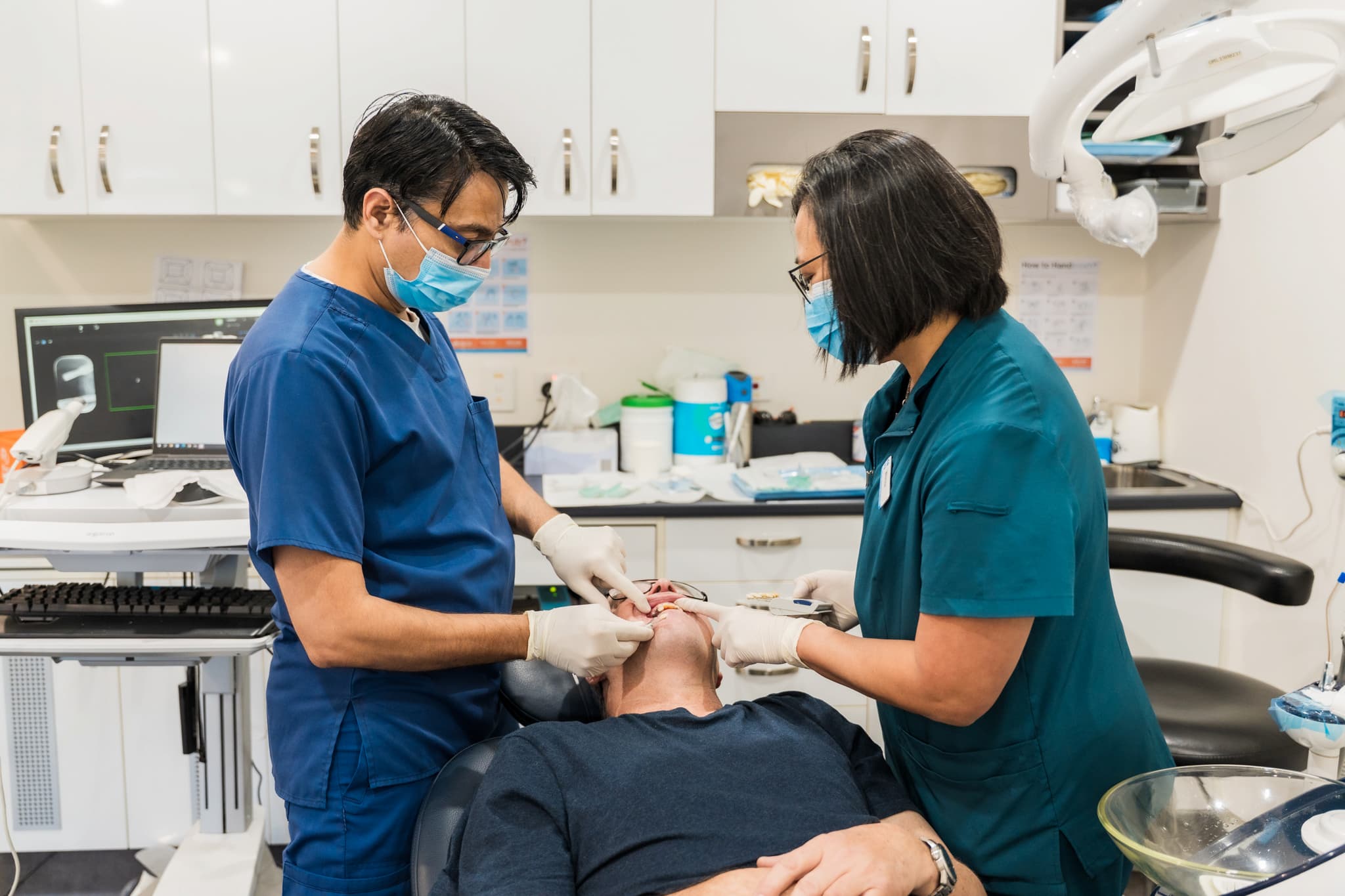 Dentists fitting a dental crown for a patient during restorative treatment
