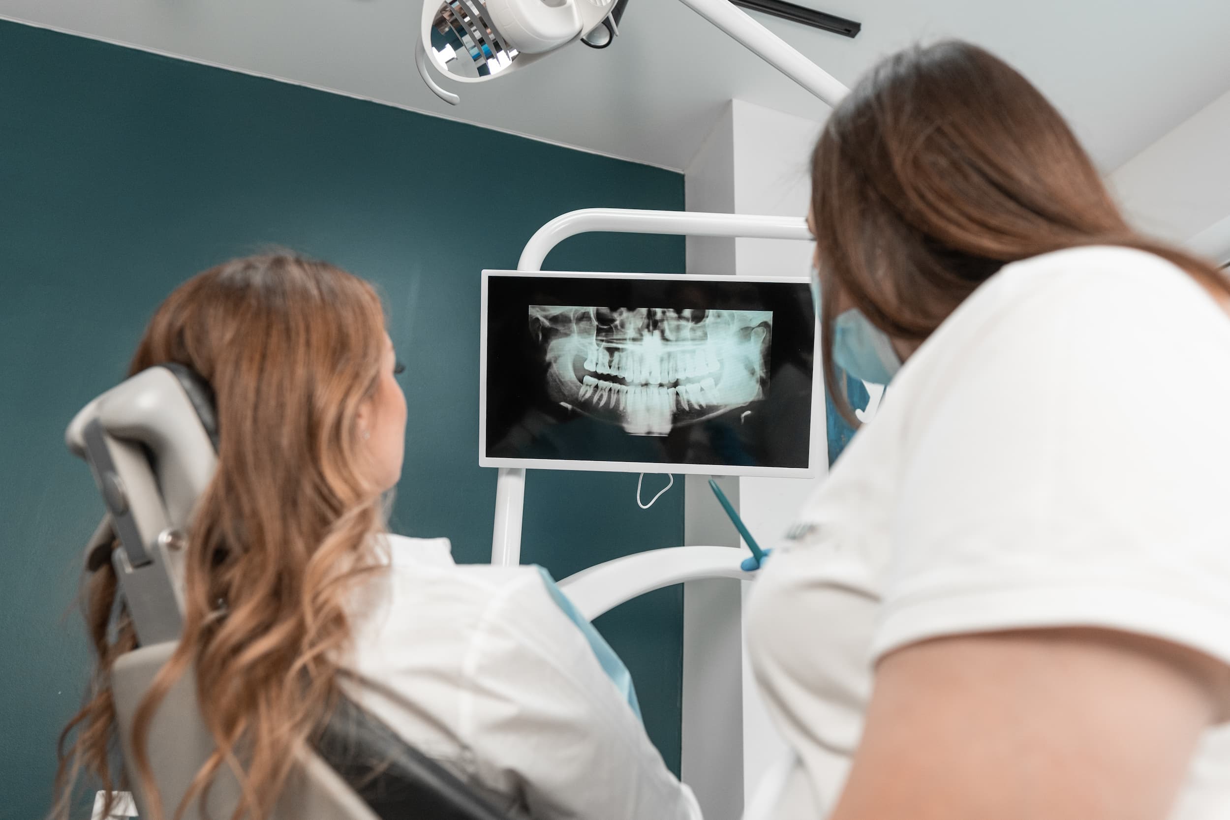 Dentist reviewing a childs dental X-ray on screen during consultation