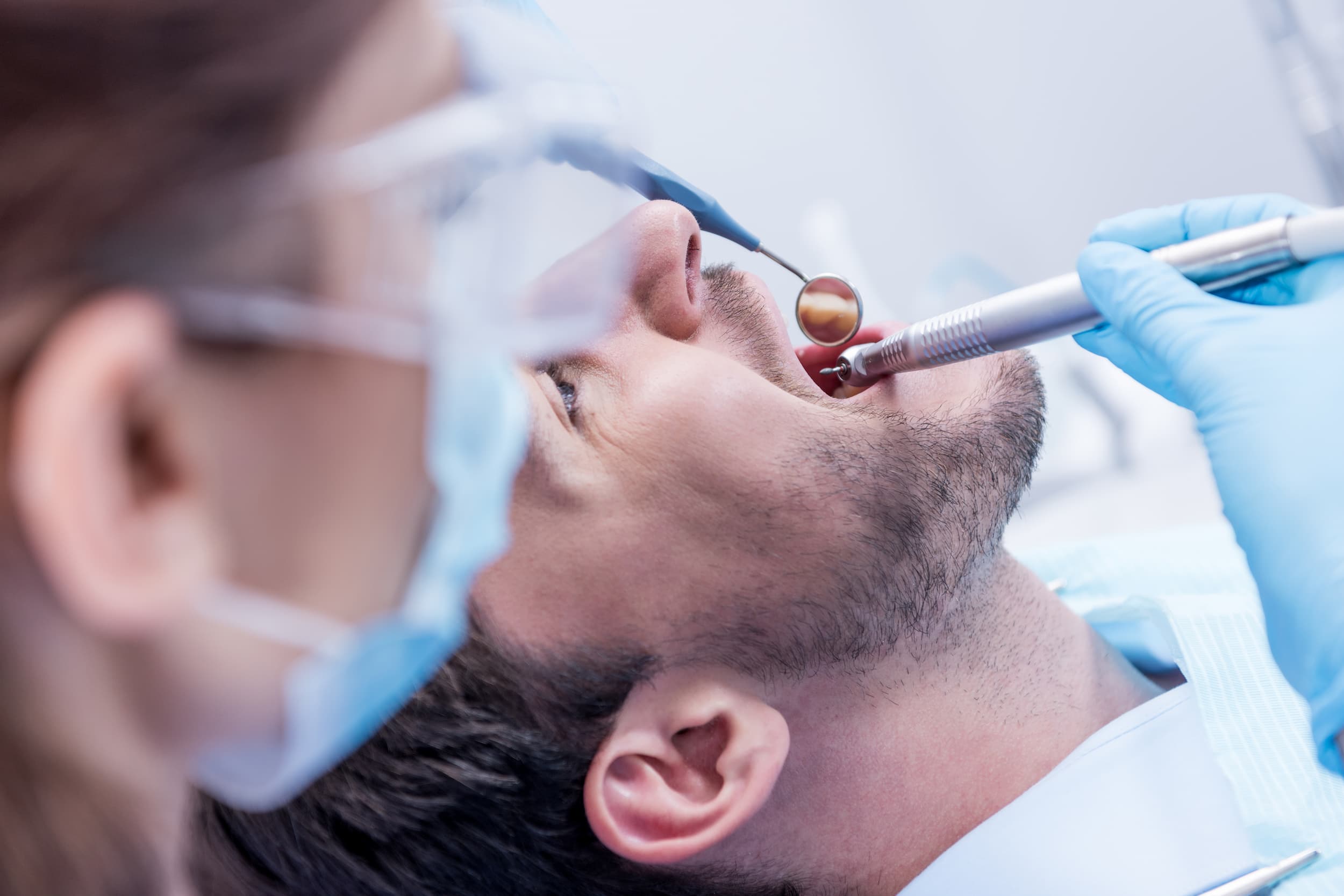 Dentist performing treatment on relaxed patient during sedation dentistry procedure